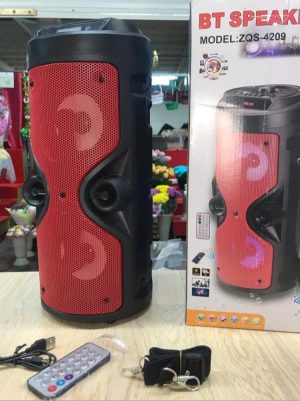 Crveni karaoke Bluetooth zvučnik model 4209 na stolu sa daljinskim upravljačem i kablovima