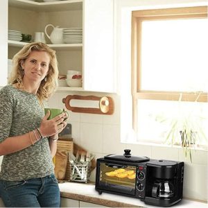 Žena u kuhinji pije kafu pored multifunkcionalnog aparata za doručak
