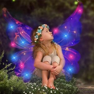 Devojčica sa plavim svetlećim vilinskim krilima sedi i sanjari u prirodi